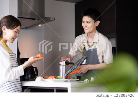 料理を作る若い夫婦 料理を作る若い夫婦 128808426