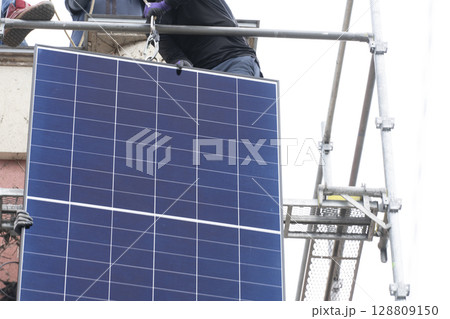 太陽光パネルを住宅の屋根に設置する工事　作業の様子 128809150