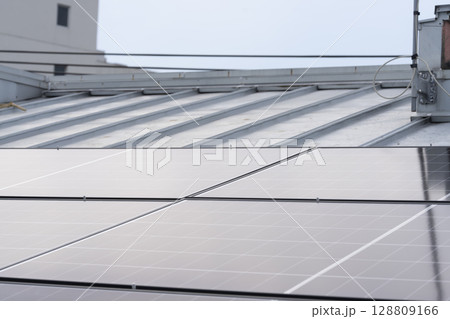 太陽光パネルを住宅の屋根に設置する工事　作業の様子 128809166