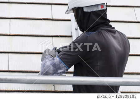 太陽光パネルを住宅の屋根に設置する工事　作業の様子 128809185