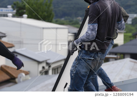 太陽光パネルを住宅の屋根に設置する工事　作業の様子 128809194