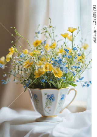 Bright spring flowers in a vintage teacup on a soft fabric surface Bright spring flowers in a vintage teacup on a soft fabric surface 128809793