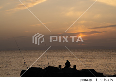 沈む夕日と釣り人 沈む夕日と釣り人 128810319