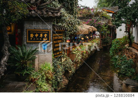 Canal-side restaurant with lush plants in Lijiang Old Town, China 128810884