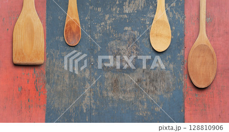 Set of Wooden Spoons and Spatulas on Rustic Distressed Wood Background. File with Clipping Path. 128810906