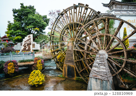 Wooden waterwheel and flower-lined stream in Lijiang Old Town Wooden waterwheel and flower-lined stream in Lijiang Old Town 128810969