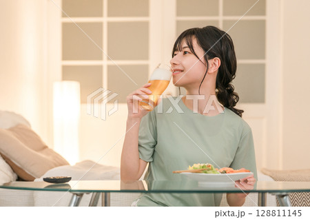 家の寝室で晩酌する若いアジア人女性（ビール,家飲み,飲酒習慣） 128811145