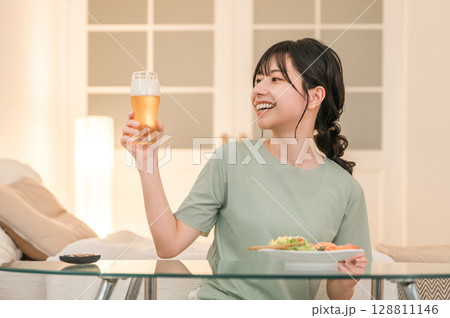 家の寝室で晩酌する若いアジア人女性（ビール,家飲み,飲酒習慣） 128811146
