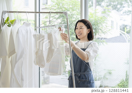 洗濯物を干す50代の女性 128811441