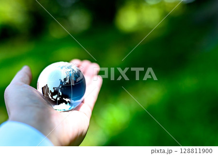 綺麗な新緑にかざす地球儀の水晶 エコロジーイメージ メタリックモノクロームカラー 綺麗な新緑にかざす地球儀の水晶 エコロジーイメージ メタリックモノクロームカラー 128811900