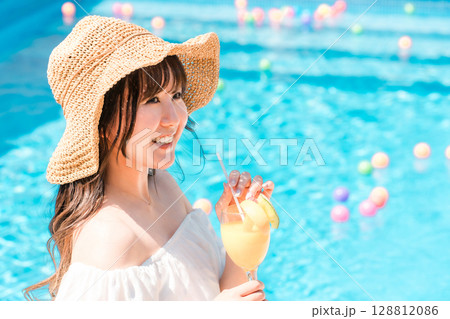 プールサイドでトロピカルジュースを飲む若いアジア人女性(リゾート・バカンス・バケーション) プールサイドでトロピカルジュースを飲む若いアジア人女性(リゾート・バカンス・バケーション) 128812086
