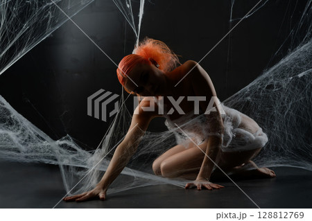 Red-haired woman entangled in a net trap surrounded by synthetic webbing 128812769