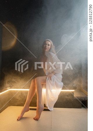 Woman enjoys relaxation in a peaceful sauna with soft lighting and steam Woman enjoys relaxation in a peaceful sauna with soft lighting and steam 128812790