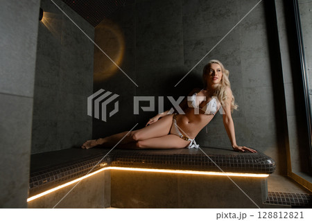 Relaxation in a sauna by a woman enjoying a spa experience 128812821