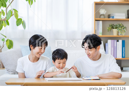 お絵かきをする子供と見守る両親。 128813126