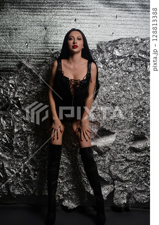 Woman showcases stylish leather accessories in a modern studio setting Woman showcases stylish leather accessories in a modern studio setting 128813388