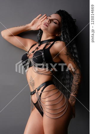 Sensual woman poses confidently in elegant lingerie with intricate details Sensual woman poses confidently in elegant lingerie with intricate details 128814669