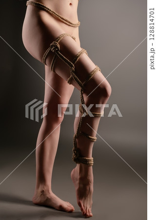Elegant shibari rope art accentuating a woman's sensuality 128814701