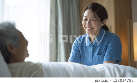 朝の見守りで微笑む30代の女性介護士と寝起きの高齢者 128814785