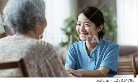 家族に説明する女性介護士 128814796