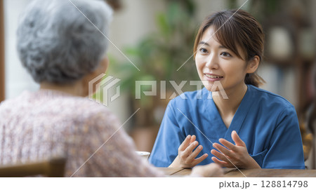 家族に説明する女性介護士 128814798