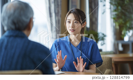 家族に説明する女性介護士 家族に説明する女性介護士 128814799