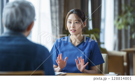 家族に説明する女性介護士 128814801