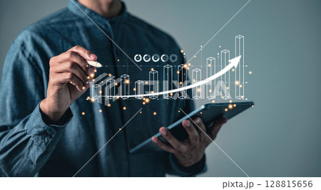 A person uses a pen to interact with a bar graph and a rising arrow on a digital tablet, displaying 128815656