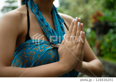 Woman in colorful clothing performs a respectful gesture 128816201