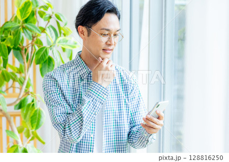 オフィスでスマホを操作するミドルのビジネスマン 128816250