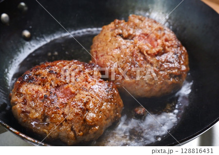 ハンバーグ - フライパンでハンバーグステーキを、ジュージュー音をさせながら焼く 128816431