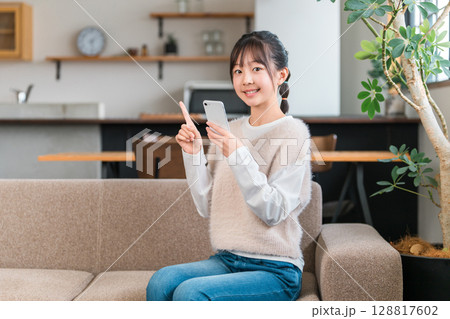 スマホ,スマートフォンのアプリを見る子供,女の子,小学生,中学生,高校生 スマホ,スマートフォンのアプリを見る子供,女の子,小学生,中学生,高校生 128817602