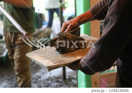 土壁を塗る男性 128818086