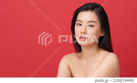 A beautiful young Asian woman with clean, fresh skin against a red background. Skincare, facial treatment, cosmetology, beauty, and spa. An elegant portrait of an Asian woman. A beautiful young Asian woman with clean, fresh skin against a red background. Skincare, facial treatment, cosmetology, beauty, and spa. An elegant portrait of an Asian woman. 128819449