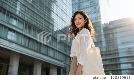 都会のオフィス街を歩くビジネスカジュアルな装いの日本人女性「生成AI」 都会のオフィス街を歩くビジネスカジュアルな装いの日本人女性「生成AI」 128819611