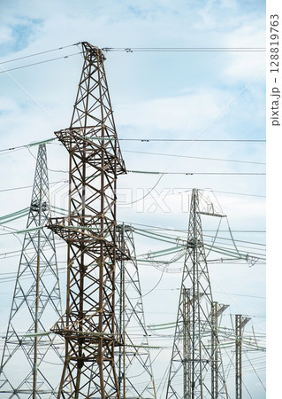 High voltage electrical power lines and transmission towers create a network for electric energy supply and industrial use. High voltage electrical power lines and transmission towers create a network for electric energy supply and industrial use. 128819763