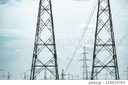 High voltage power lines and electrical towers against a clear sky for electricity distribution 128819764