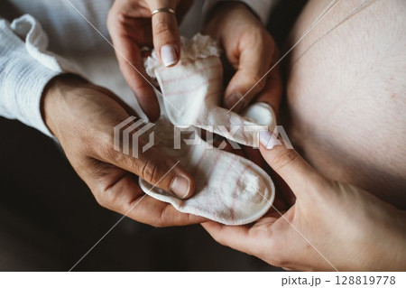 Expectant Parents Holding Baby Socks with Tenderness Expectant Parents Holding Baby Socks with Tenderness 128819778