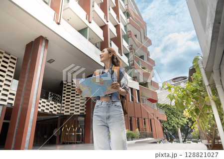 Adventurous woman navigating city with map 128821027