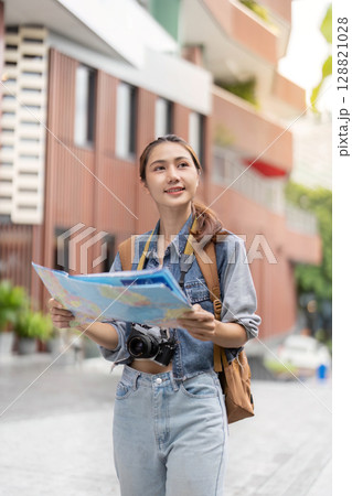 Young traveler reading map while exploring city streets 128821028