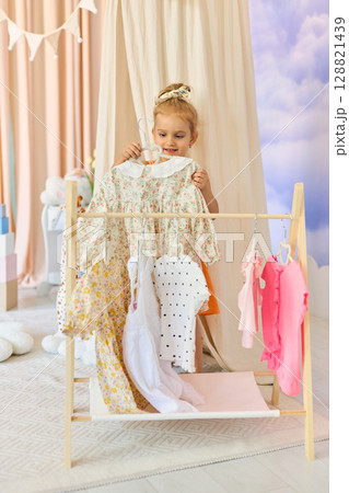 Little child girl choosing her clothes. 128821439