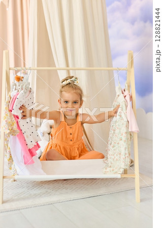 A little girl chooses what clothes to wear 128821444