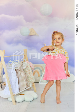 Little child girl choosing her clothes. Little child girl choosing her clothes. 128821450