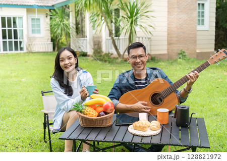 Joyful couple enjoying outdoor coffee time in a garden 128821972
