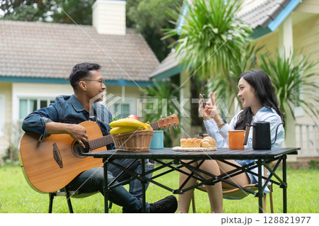 Joyful Interaction. Friends capturing moments while enjoying snacks and music outdoors. Joyful Interaction. Friends capturing moments while enjoying snacks and music outdoors. 128821977