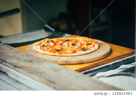 Chef Preparing Homemade Pizza with Ham and Basil 128822461