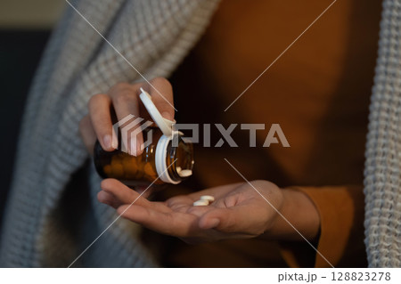 Self-Care Routine. Woman pouring pills from medicine bottle into hand. Self-Care Routine. Woman pouring pills from medicine bottle into hand. 128823278