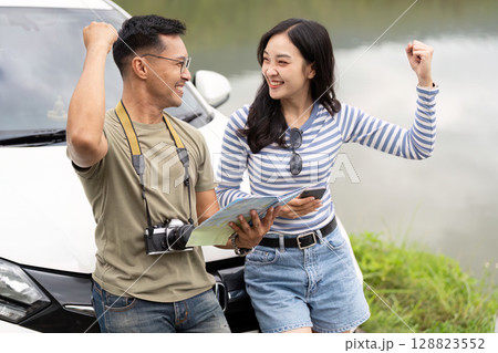 Couple celebrating adventure with joy by the lakeside Couple celebrating adventure with joy by the lakeside 128823552