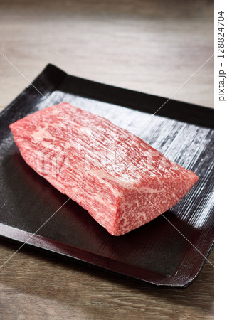 A5ランク黒毛和牛のもも肉ブロックを黒い角皿に盛り付けた高級感あふれる食材写真 A5ランク黒毛和牛のもも肉ブロックを黒い角皿に盛り付けた高級感あふれる食材写真 128824704