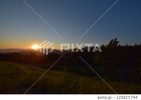 鮮烈な夕日と山岳の風景 128825794